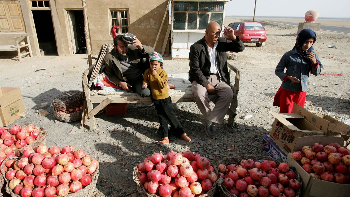 Chinese Uighurs sell pomegranates in Pishan, Xinjiang, in a file photo from 2006. 