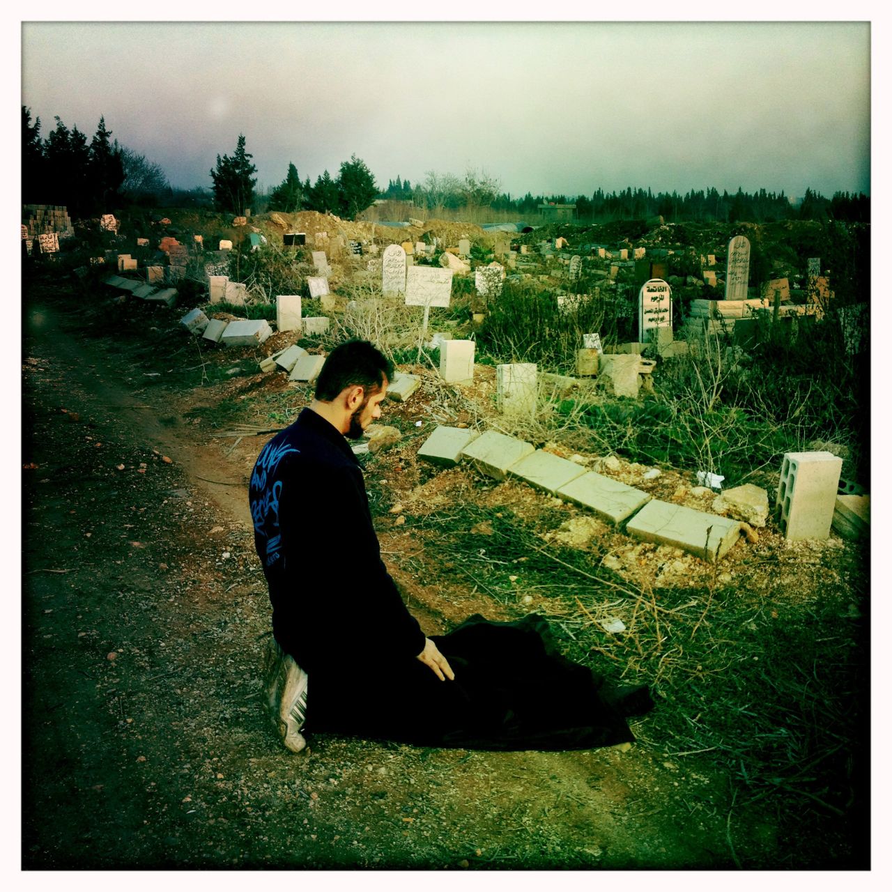 A man prays at the Baba Amr cemetery in Homs as government forces tighten their siege of rebellious neighborhoods.