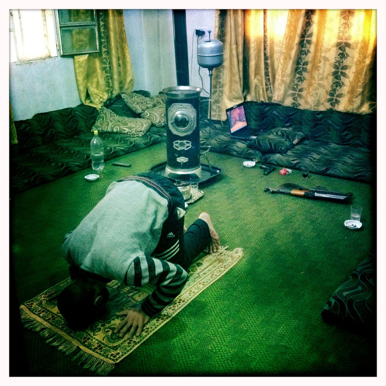 A defected officer, "Razik," prays at a safe house in Homs.