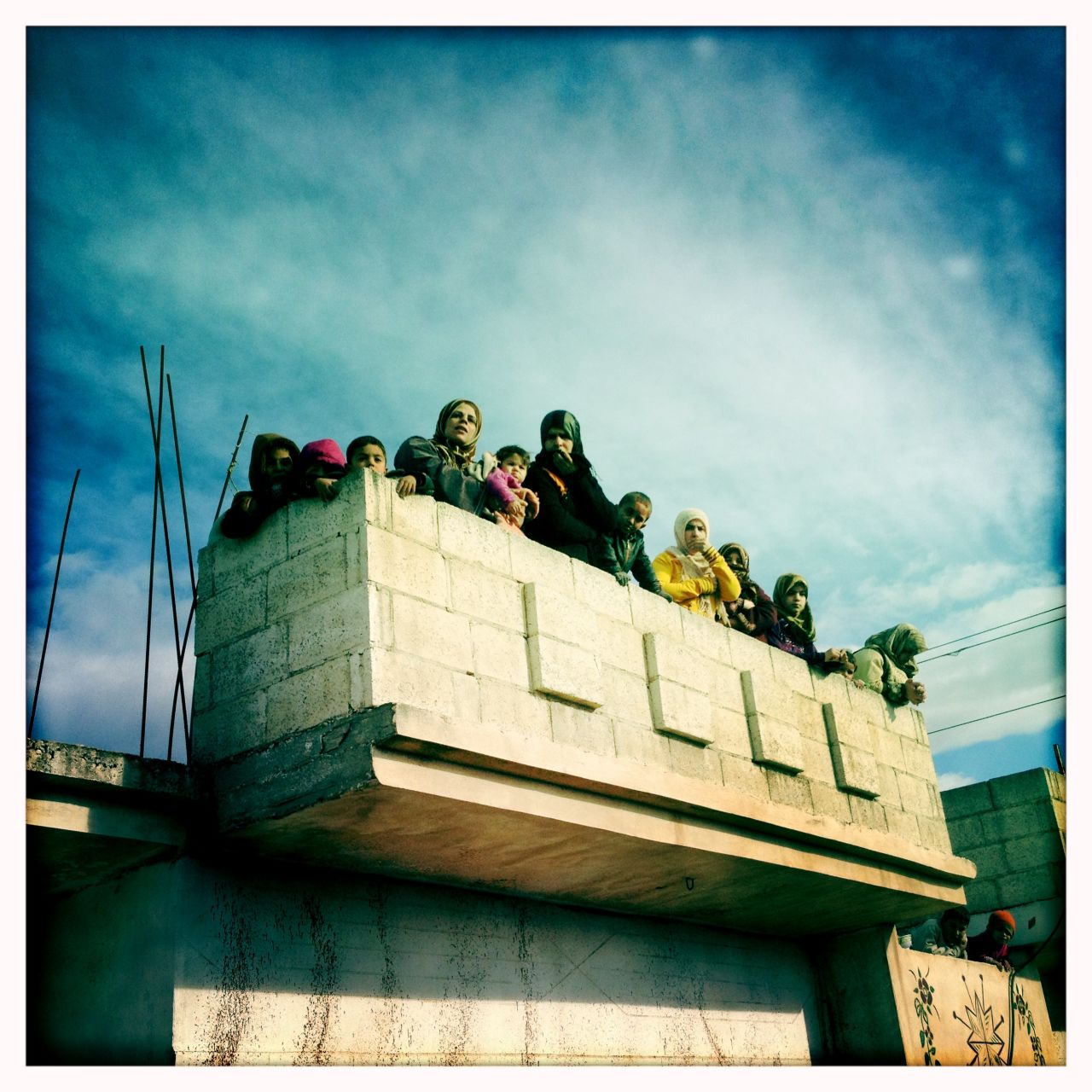 Women watch over the funeral procession for "Malik" in Dar al-Kabira.