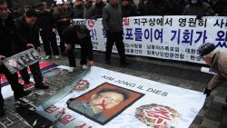 Anti-North Korea protesters place fmr leader Kim Jong-Il's portrait on ground during a demonstration in Seoul on December 28, 2011.