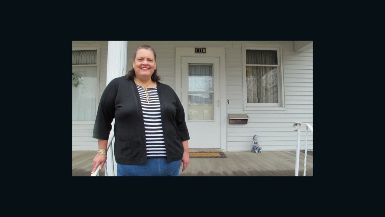 Kathy Potts stands on the front porch of her Cedar Rapids home where she plans to hang her Perry 2012 barn sign.