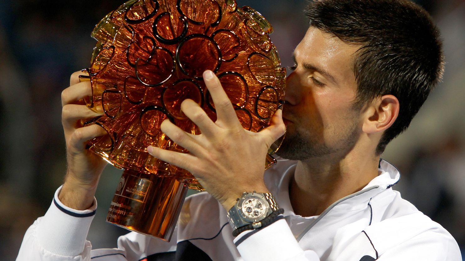 Novak Djokovic kisses the winning trophy after claiming the Abu Dhabi exhibition tournament.