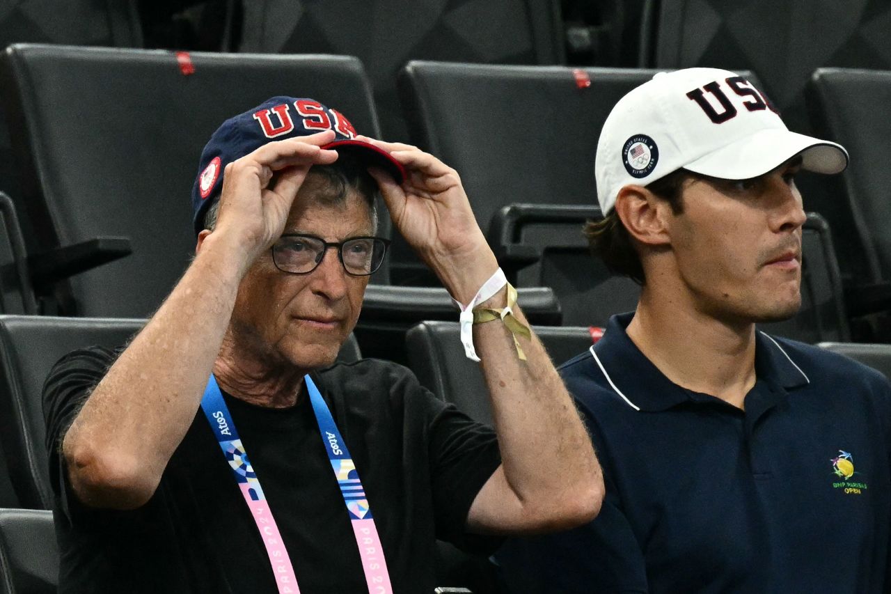 Bill Gates waits for the start of the gymnastics women's team final.