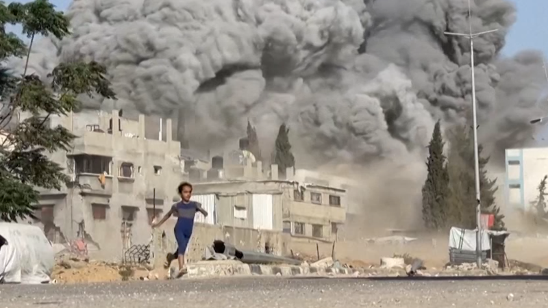 Child runs away as Israeli munitions strike Gaza refugee camp Child runs away as Israeli munitions strike Gaza refugee camp
