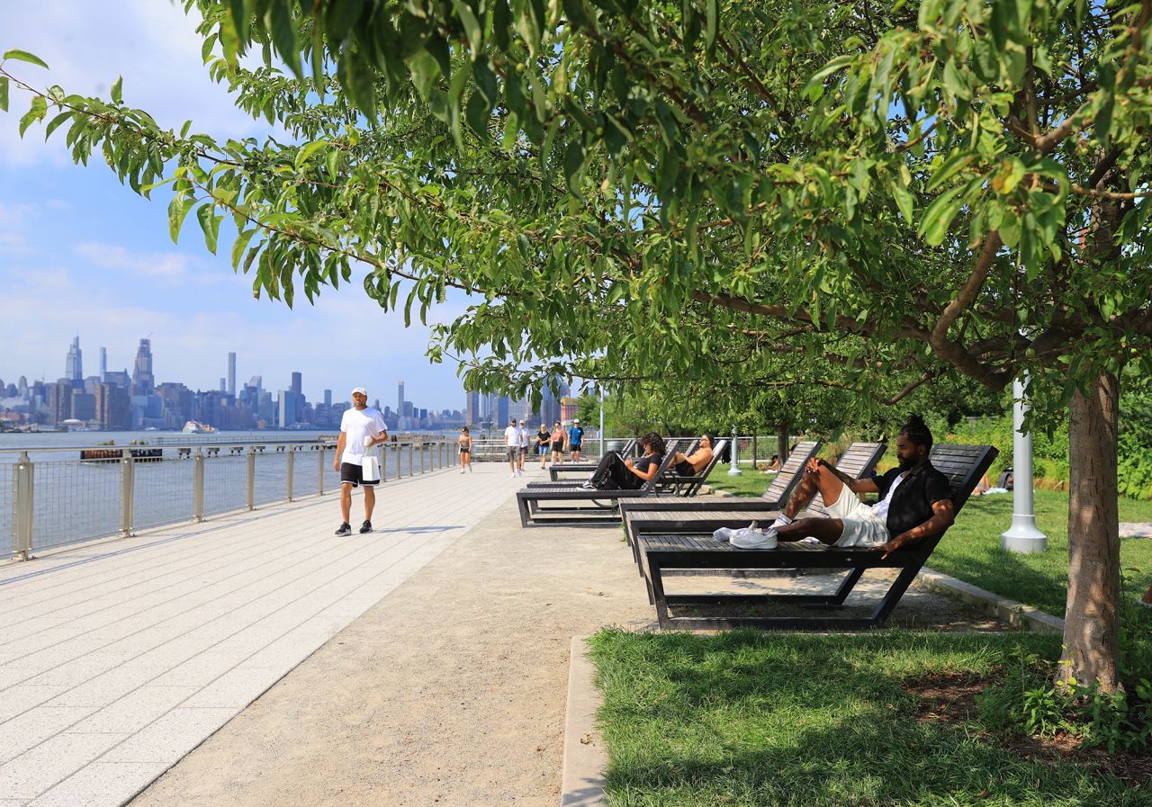 People pass their time on benches during hot weather in Brooklyn, New York, on June 17.