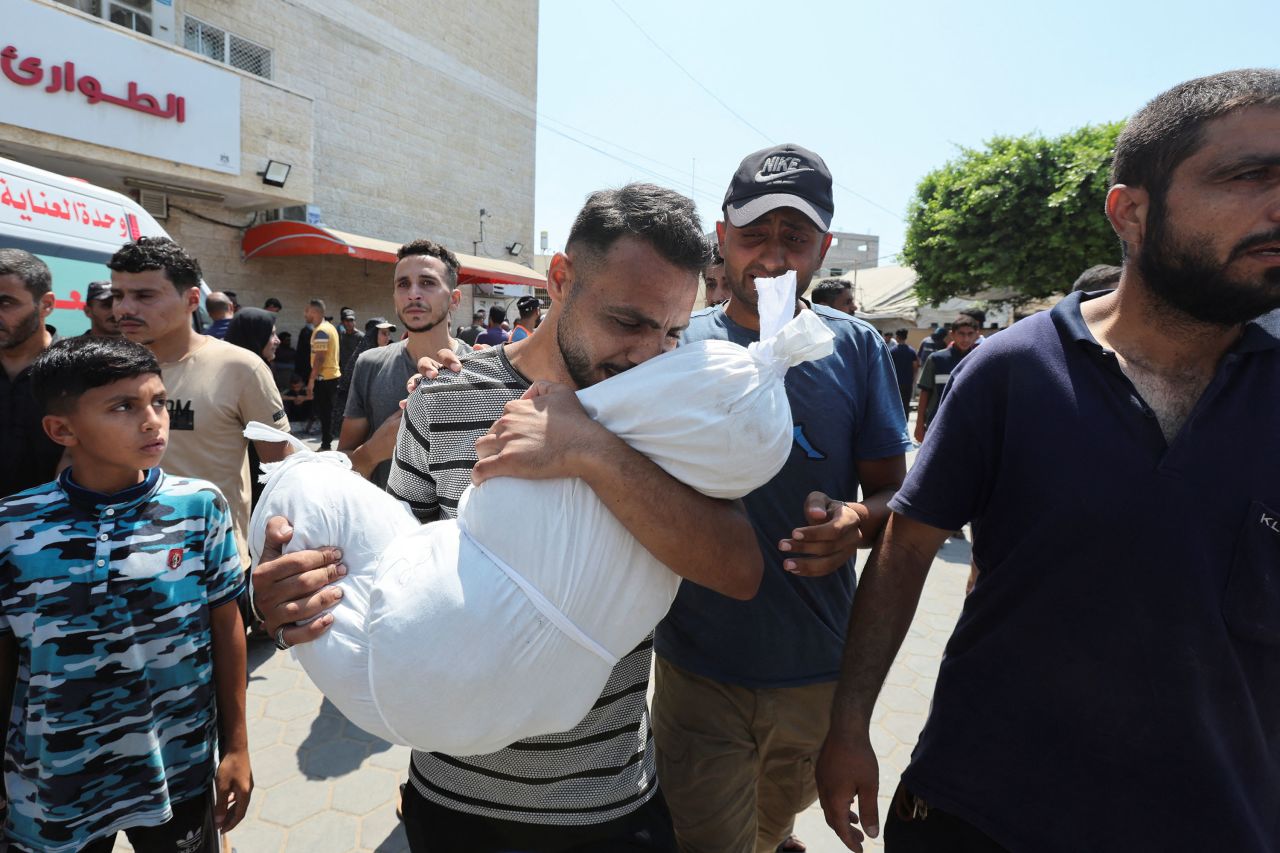 A man carries the body of a victim following an Israeli strike, in Deir Al-Balah, Gaza, on July 27. 