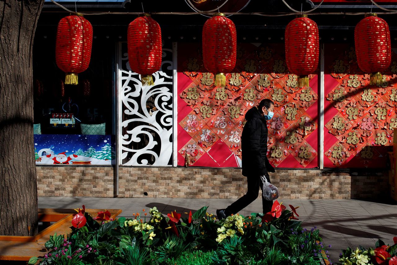 A man wearing a face mask walks past a closed restaurant in Beijing on March 4.