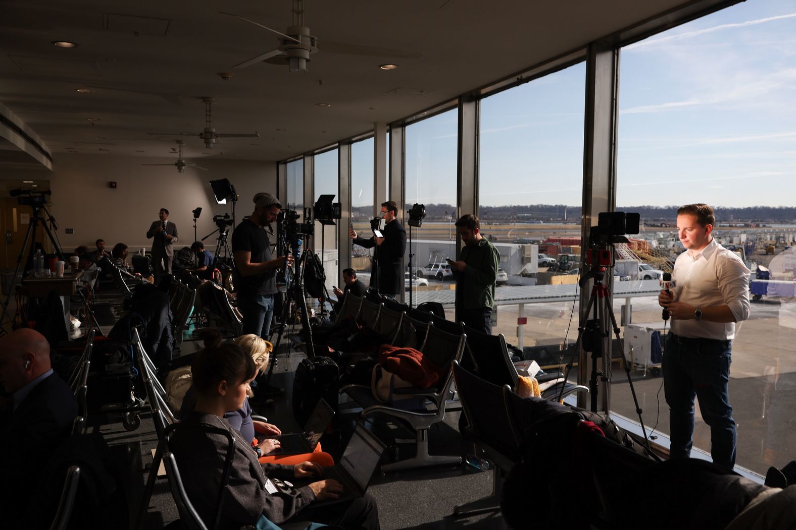 Members of the media work at Reagan National Airport on Thursday.