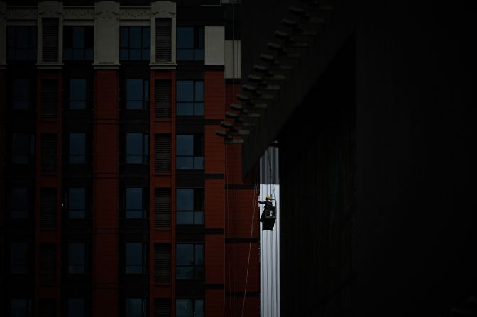 A worker uses a gondola lift at a construction site in Beijing on Monday, May 26.