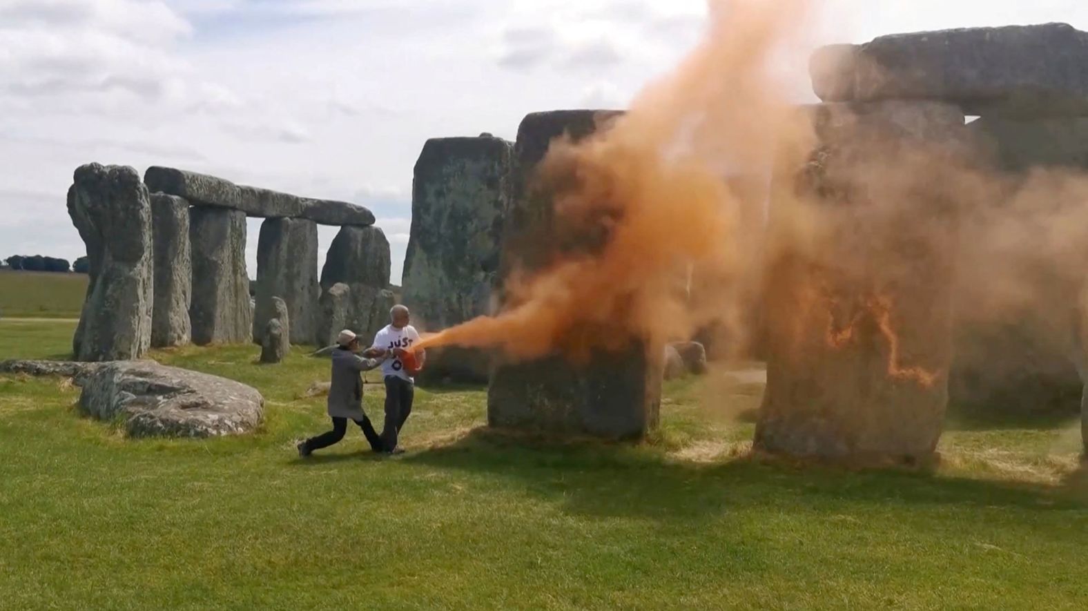 In this screengrab taken from video, environmental protesters spray Stonehenge with orange powder paint in Wiltshire, England, on Wednesday, June 19. <a href="index.php?page=&url=https%3A%2F%2Fwww.cnn.com%2F2024%2F06%2F19%2Ftravel%2Fprotesters-spray-stonehenge-paint-gbr-scli-intl%2Findex.html">The paint has since been removed</a>, leaving “no visible damage,” according to the organization that manages the site.