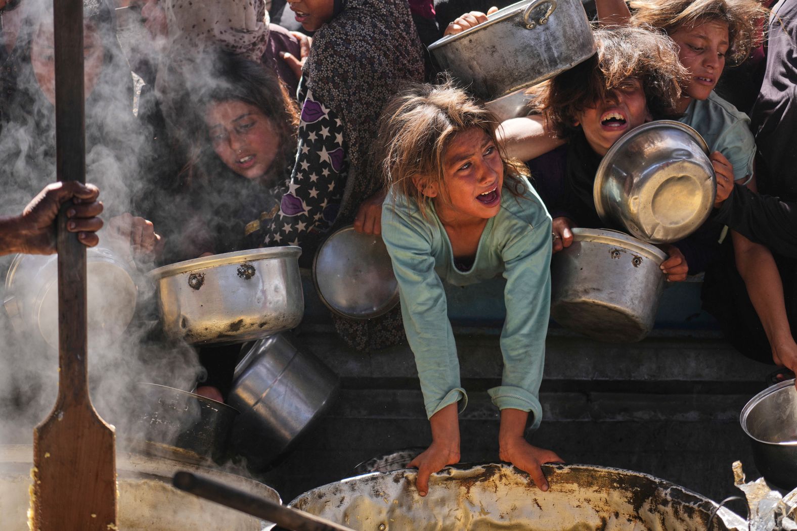 Palestinians struggle to get donated food at a community kitchen in Khan Younis, Gaza, on Friday, May 16. Aid agencies warn that <a href="https://www.cnn.com/2025/05/22/middleeast/gaza-aid-trickles-un-not-enough-intl">much of Gaza will be on the verge of famine</a> if supplies are not allowed into the enclave in volume. Until this week, Israel had forbidden all humanitarian aid entering Gaza since March 2, saying Hamas was stealing and profiting from it. Israeli leader Benjamin Netanyahu said Thursday that more than 100 humanitarian aid trucks entered the enclave on Wednesday.