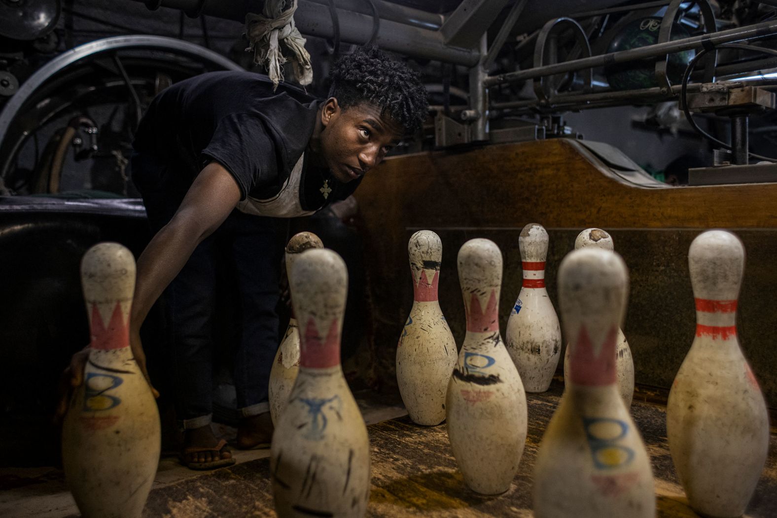 An employee manually resets bowling pins at Guenet Bowling in Addis Ababa, Ethiopia, on Friday, February 2. The employees there also keep score and throw the balls back. The vintage bowling alley was inaugurated in 1955.