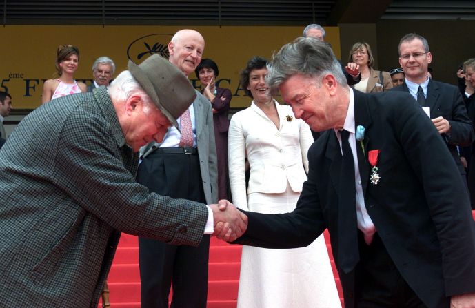 Lynch shakes hands with actor Michel Piccoli at the 2002 Cannes Film Festival.