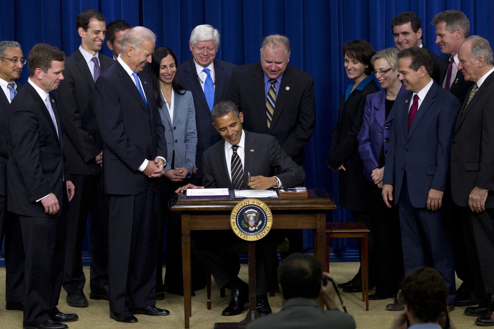 Walz and other lawmakers watch President Barack Obama sign the Stop Trading on Congressional Knowledge Act in April 2012.