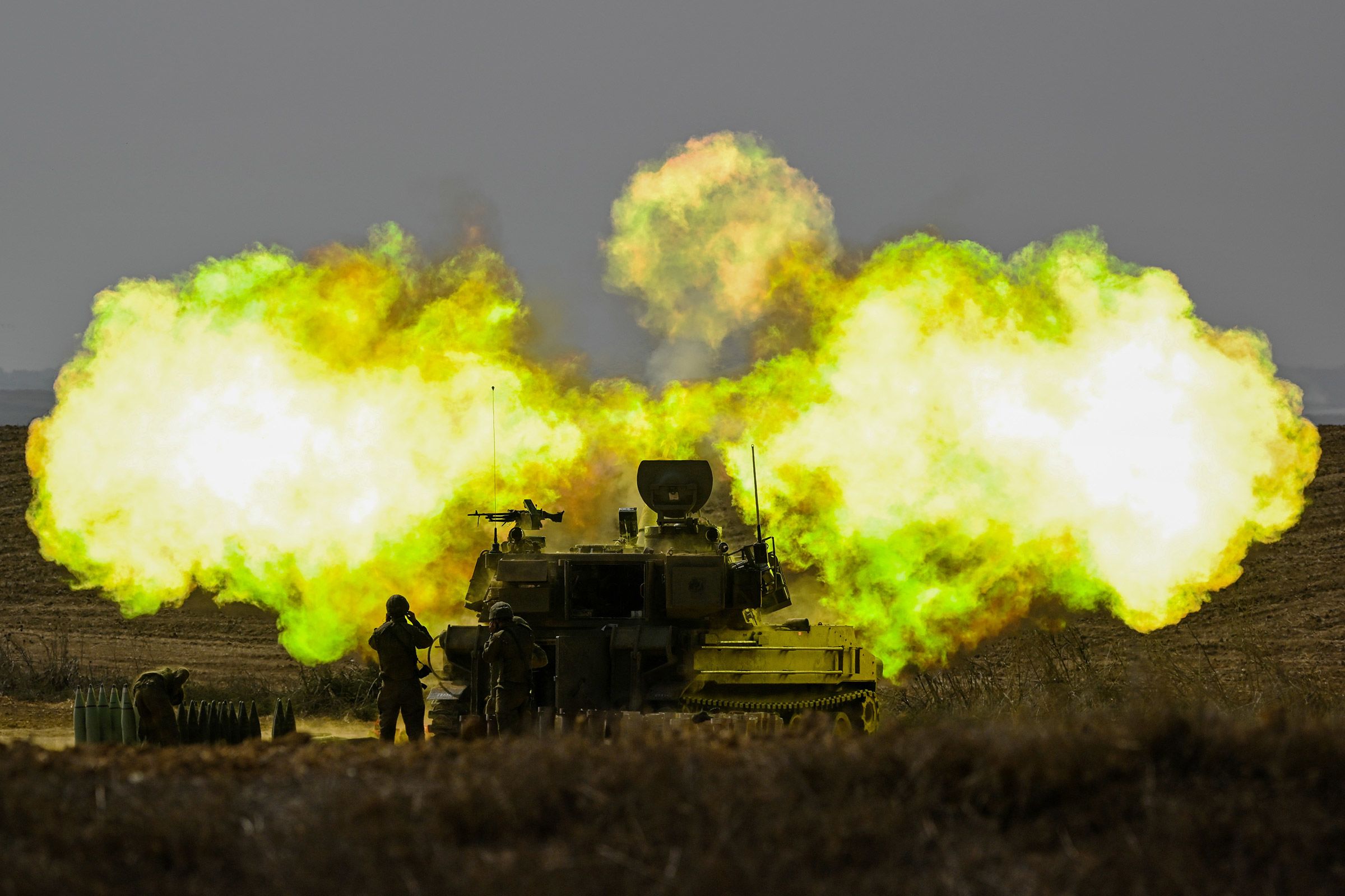 An Israeli soldier covers his ears as a shell is fired toward Gaza near Netivot, Israel, on October 11.