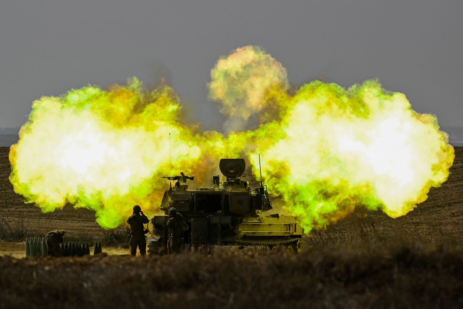 An Israeli soldier covers his ears as a shell is fired toward Gaza near Netivot, Israel, on October 11.