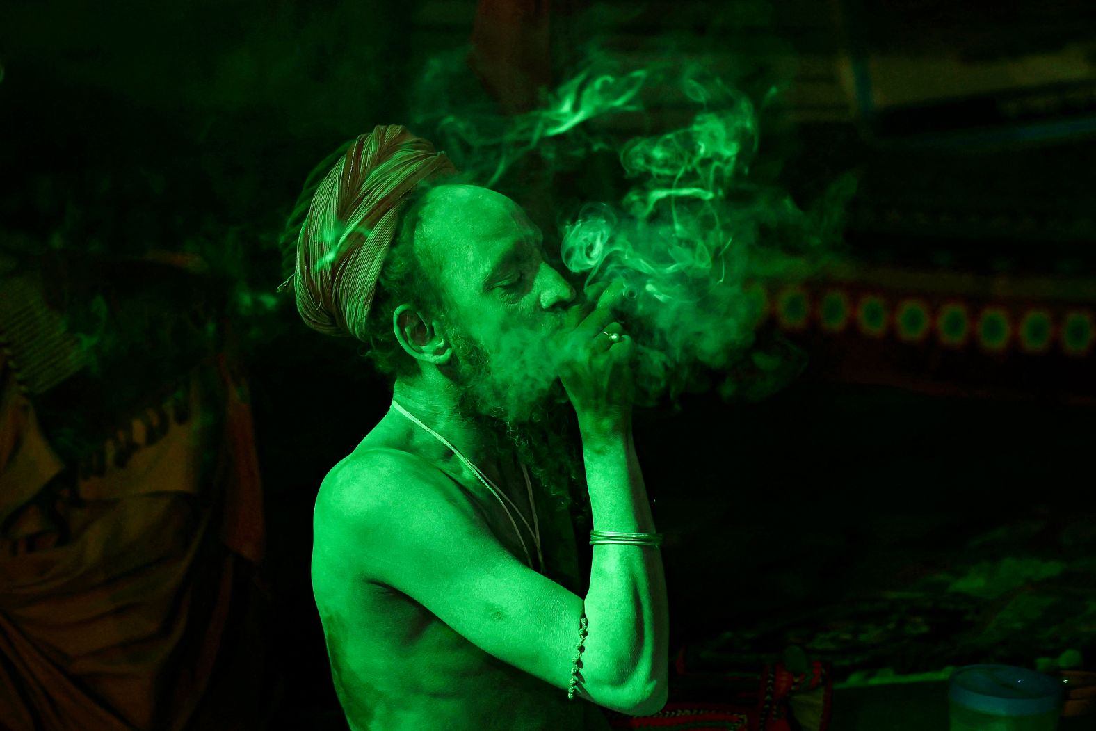 Ahead of the Kumbh Mela festival, a Hindu holy man smokes a traditional clay pipe at a camp in Prayagraj, India, on Friday, January 3.