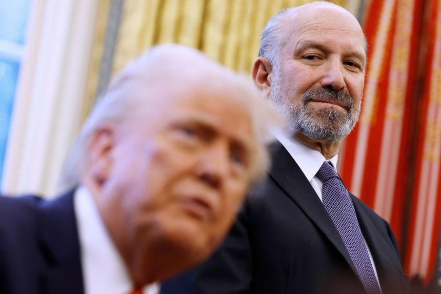 Commerce Secretary Howard Lutnick observes as President Donald Trump speaks to reporters in the Oval Office in February.