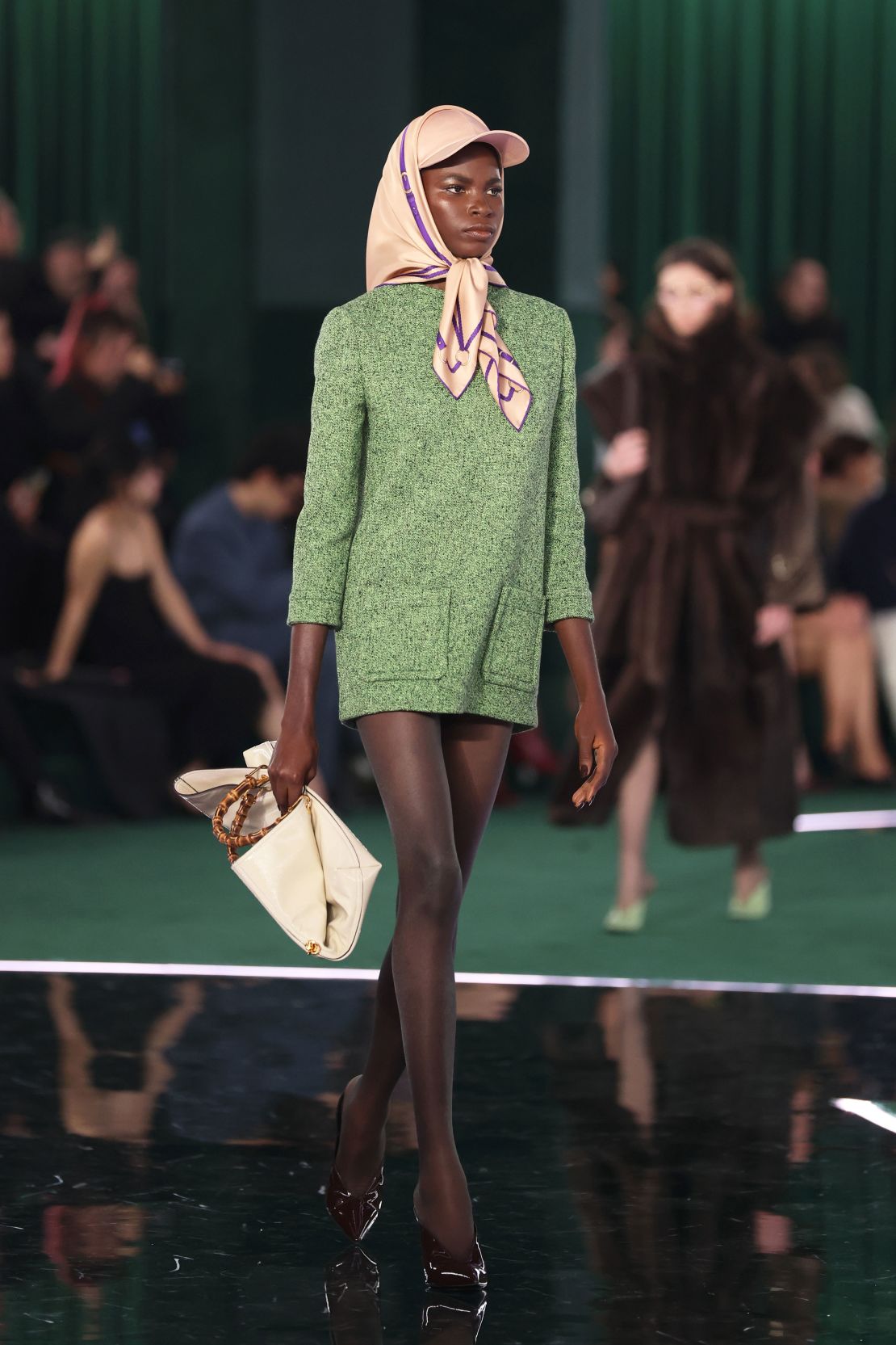 Former Gucci designer Sabato de Sarno's signature red was replaced by a shade of green, as models walked on a runway shaped like the Interlocking G logo.