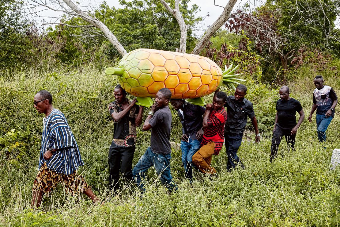 A pineapple seller is carried to her grave in a pineapple-shaped coffin in the Greater Accra region in 2019. According to Tschumi it is the family of the deceased who typically decide the shape of the coffin.