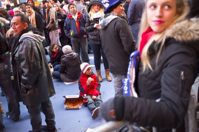 A young celebrator enjoys a slice of pizza in Times Square before the festivities begin.