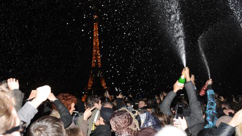 	People spray champagne as they celebrate the New Year on the Trocadero square in front of the Eiffel Tower in Paris early on January 1, 2012.