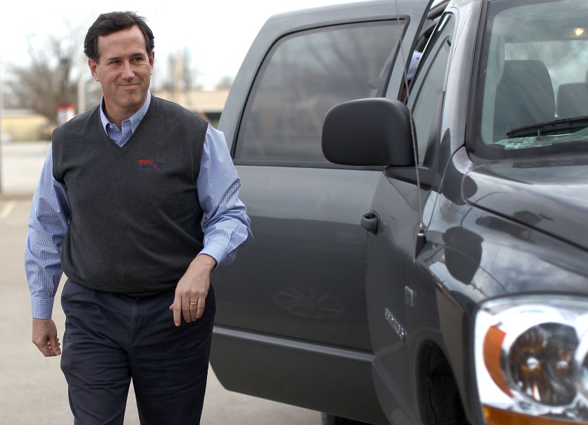 Santorum strides confidently out of a pickup truck in Knoxville, Iowa, in a gray sweater vest embroidered with his name. Guess his mom doesn't have to write on the tag anymore ...  