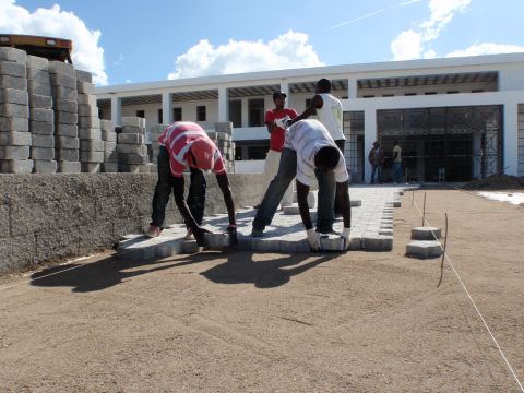 Local workers lay paving stones at the front entrance to Mirebalais National Teaching Hospital in Haiti. The hospital will open this year and boasts a neonatal intensive care unit and six operating rooms that can handle thoracic surgery.