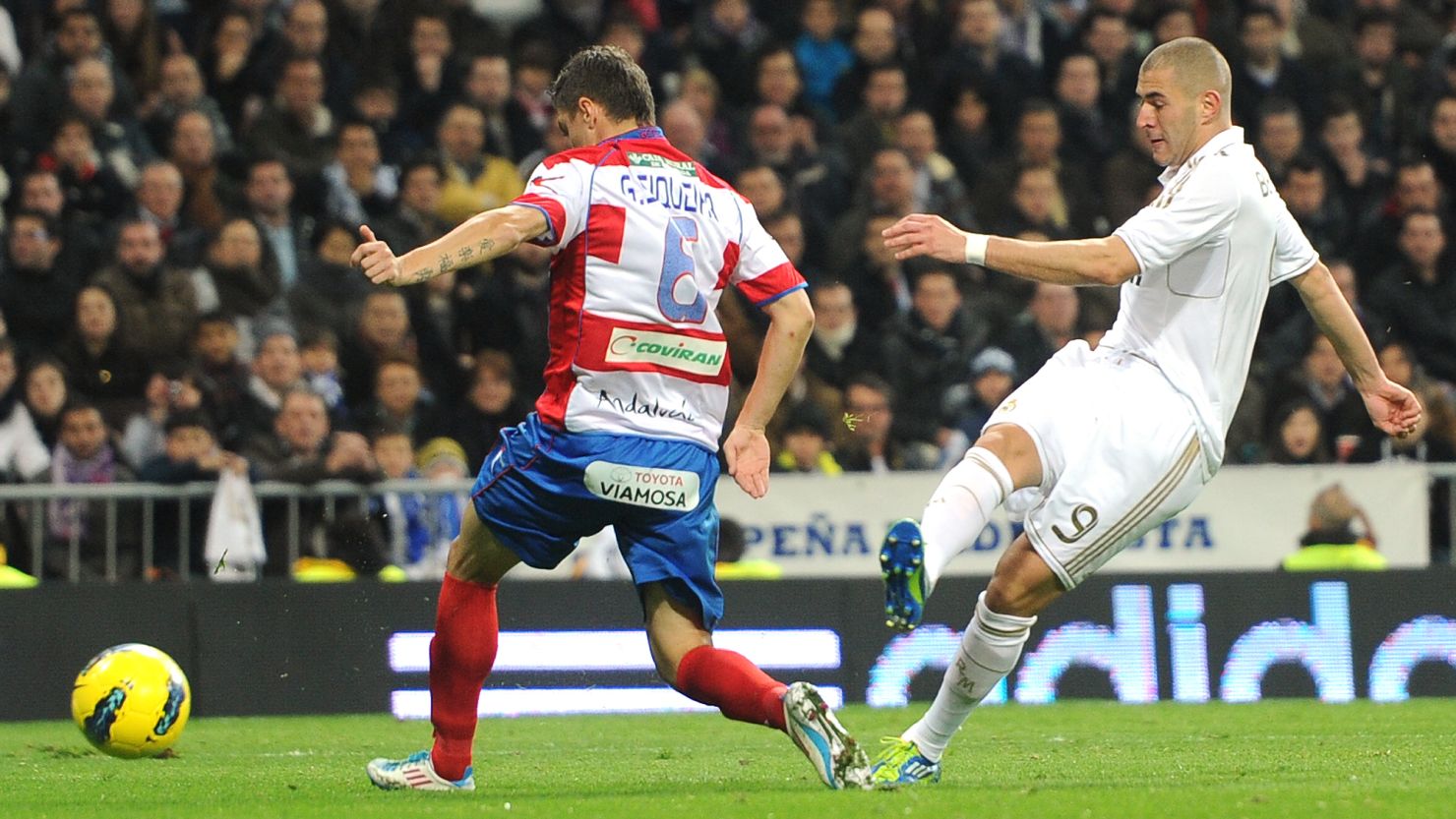 Karim Benzema scores one of his two goals for Real Madrid against Granada at the Santiago Bernabeu stadium.