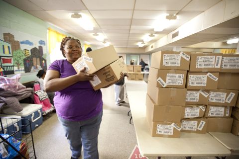 Andono stacks and organizes food for distribution at the co-op, which meets in the basement of the Georgia Avenue Presbyterian Church.