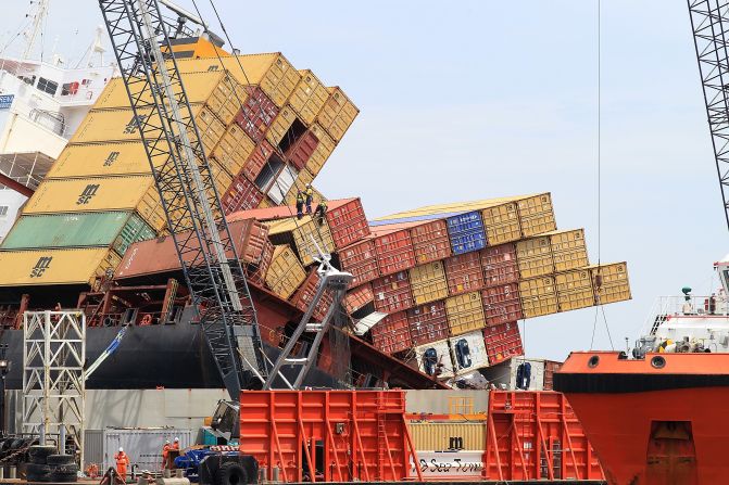 Workers remove shipping containers from the Rena on November 17,  2011.