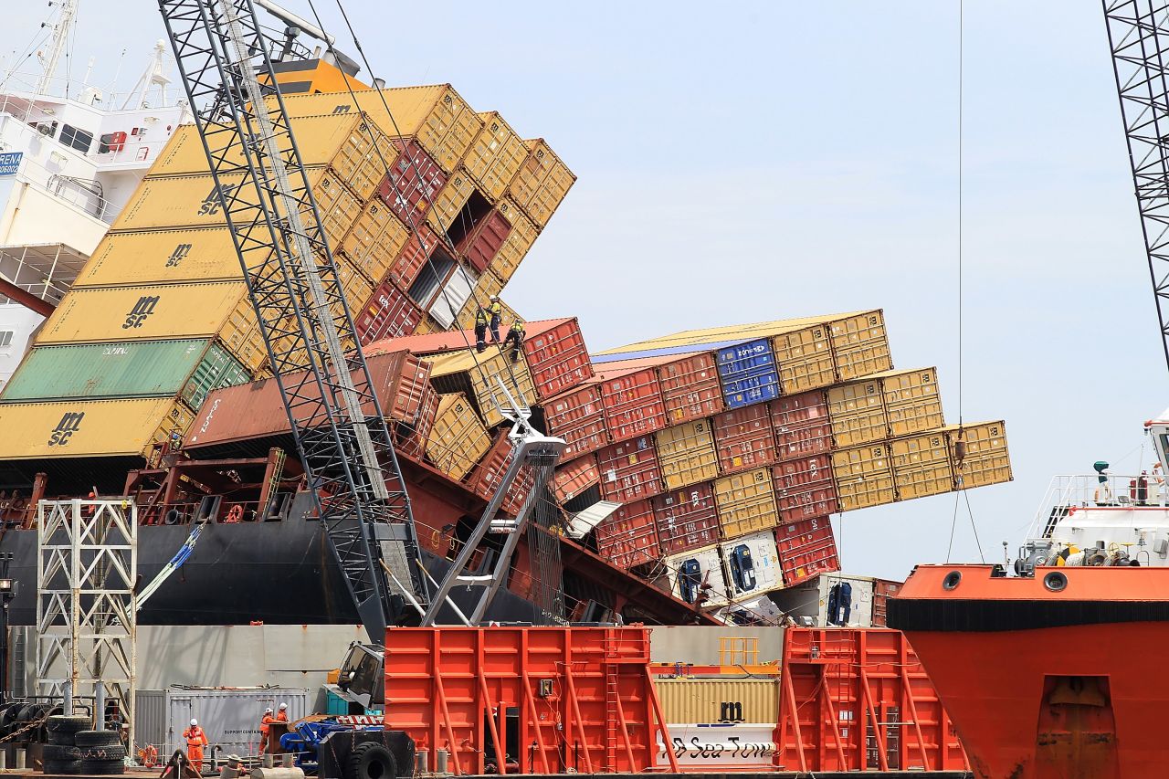 Workers remove shipping containers from the Rena on November 17,  2011.