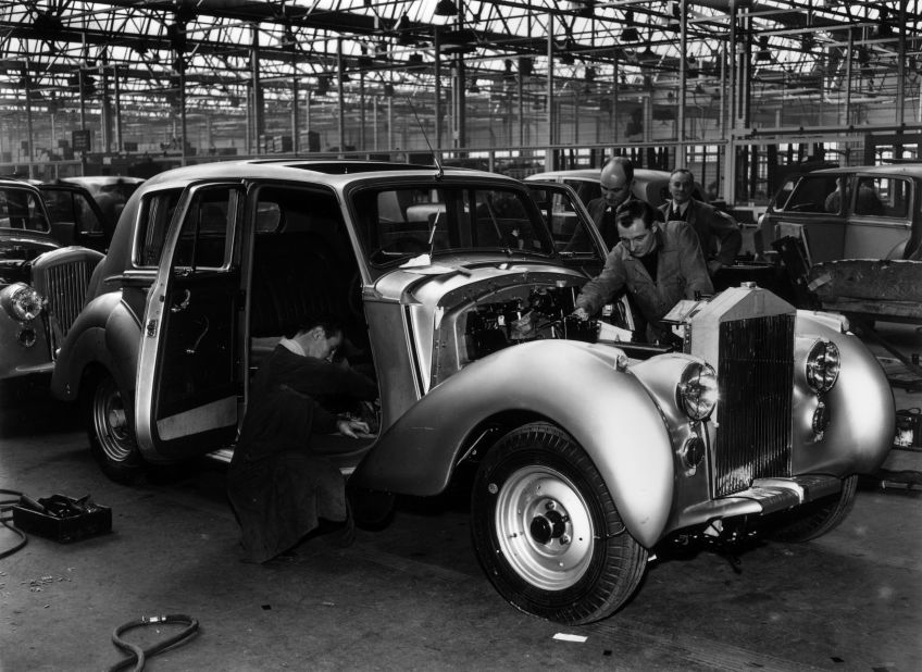 Rolls-Royce craftsmen show their attention to detail as a Silver Dawn rolls down the assembly line at Crewe in 1950.