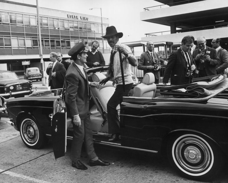 No better way to arrive: Actor, singer, dancer, Sammy Davis Jnr takes delivery of a black Rolls-Royce convertible at London Airport in 1969.