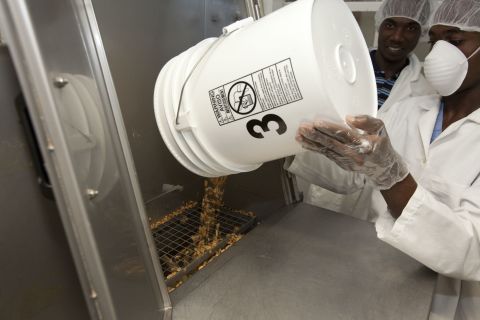 MFK employees add peanuts during the manufacturing of "Medika Mamba." MFK's primarily Haitian staff produces this and other therapeutic foods to fight malnutrition across the country.