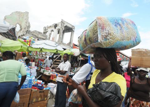 Haitian vendors sell their goods in Port-au-Prince amid earthquake-damaged buildings. The United Nations says 50% of the rubble left by the January 12, 2010, earthquake still litters the Haitian capital.