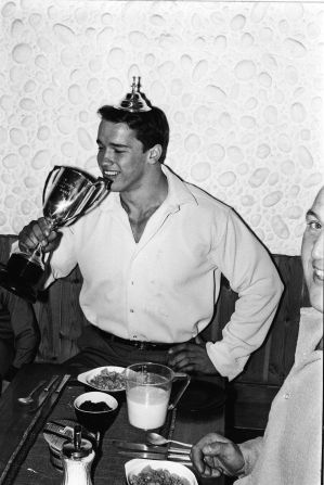 Austrian bodybuilder and future Californian governor Arnold Schwarzenegger pretends to drink from his trophy while wearing its lid as a crown after winning the Mr. Universe contest in London, England, in September 1967.