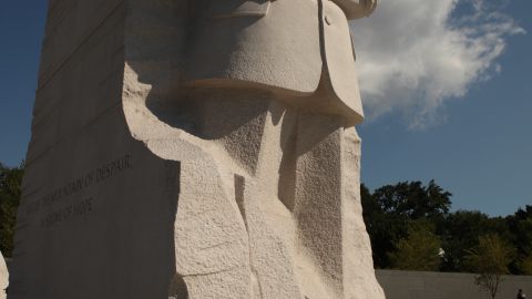 The 30-foot, 8-inch granite statue of King stands among cherry trees on four acres on the northwest shore of Washington's Tidal Basin.  The statue depicts the king in a suit with his arms folded, holding a scroll and gazing at a basin.