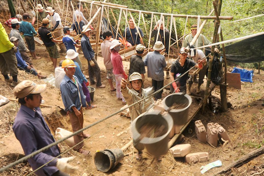 Vietnamese workers use a zip line to move dirt from a dig site to a screening area in the Thua Thien-Hue province, Vietnam.