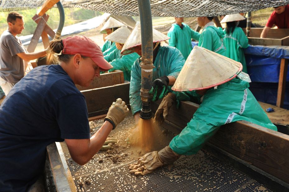 U.S. Army Staff Sgt. Nicole McMinniman, left, screens dirt with the help of local workers during recovery operations in the Savannakhet province, Laos.