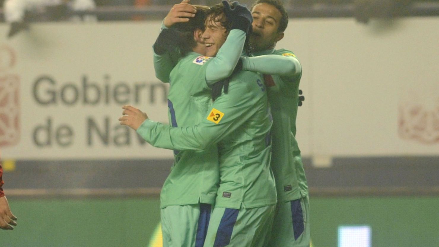 Barcelona players celebrate their winning goal over Osasuna on a foggy evening in Pamplona.