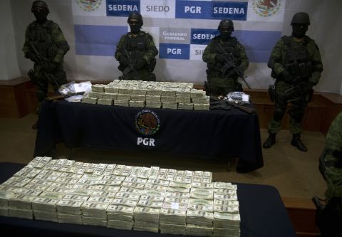 Mexican army soldiers display $15 million U.S. on November 22, 2011, in Mexico City. The money was seized from alleged members of the Guzman Loera drug cartel during a raid in the border town of Tijuana, Mexico.