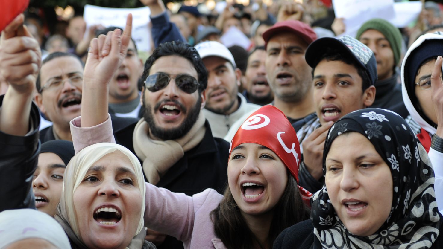 People in Tunis shout slogans to commemorate the first anniversary of a demonstration that led to the fall of their president.