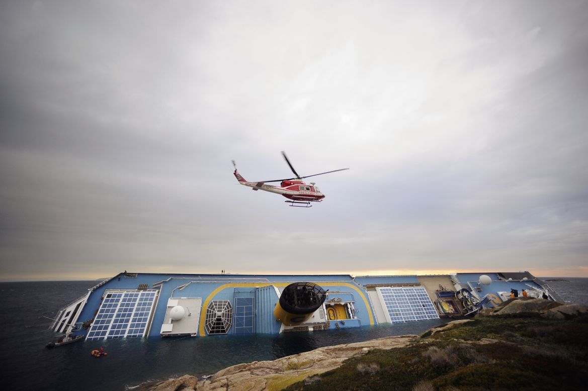Firemen search for missing people in and around the partially submerged Costa Concordia cruise ship on January 16.