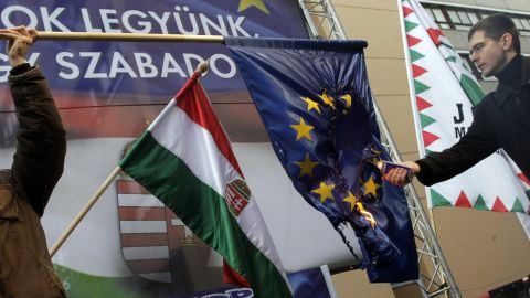 Member of the Hungarian Parliament and the Hungarian right-wing 'Jobbik' party, Elod Novak, right, sets an European Union flag on fire during a demonstration in Budapest on January 14, 2012.