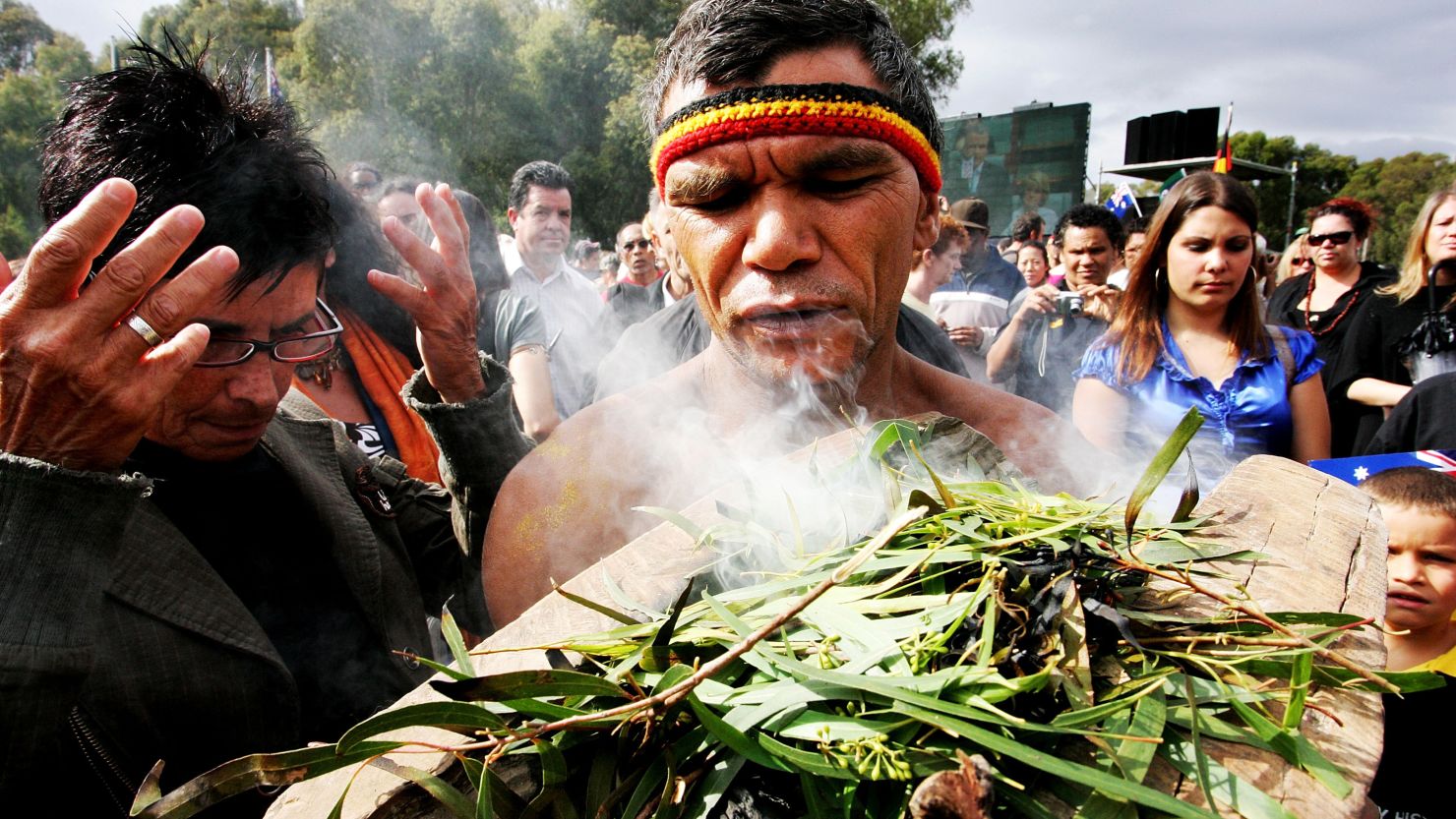 An Aboriginal man performs a smoke cleansing ceremony on the Parliament lawns, Canberra on February 13, 2008.