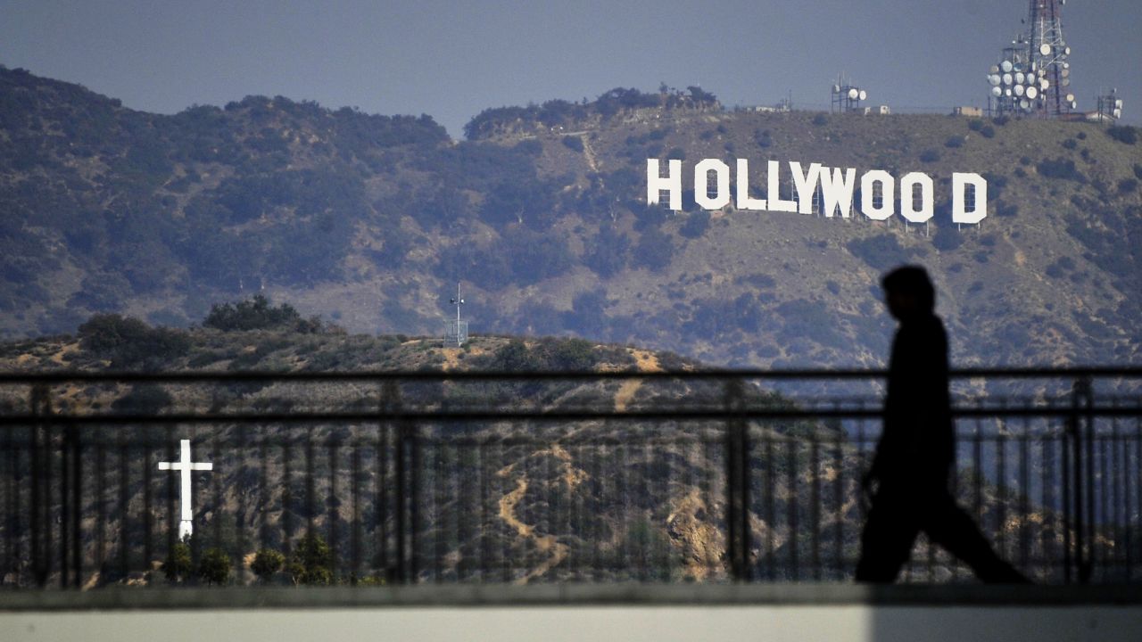 A walker passes in front of the iconic "Hollywood" sign in Los Angeles, where severed body parts were found this week.