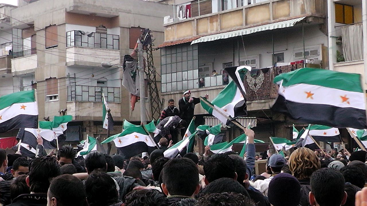 Anti-government demonstrators wave former Syrian flags in the Khalidiya neighborhood in Homs on January 20.