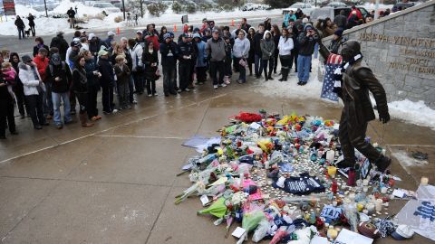 People pay their respects on Sunday at the statue of former Penn State football coach Joe Paterno after news of his death.